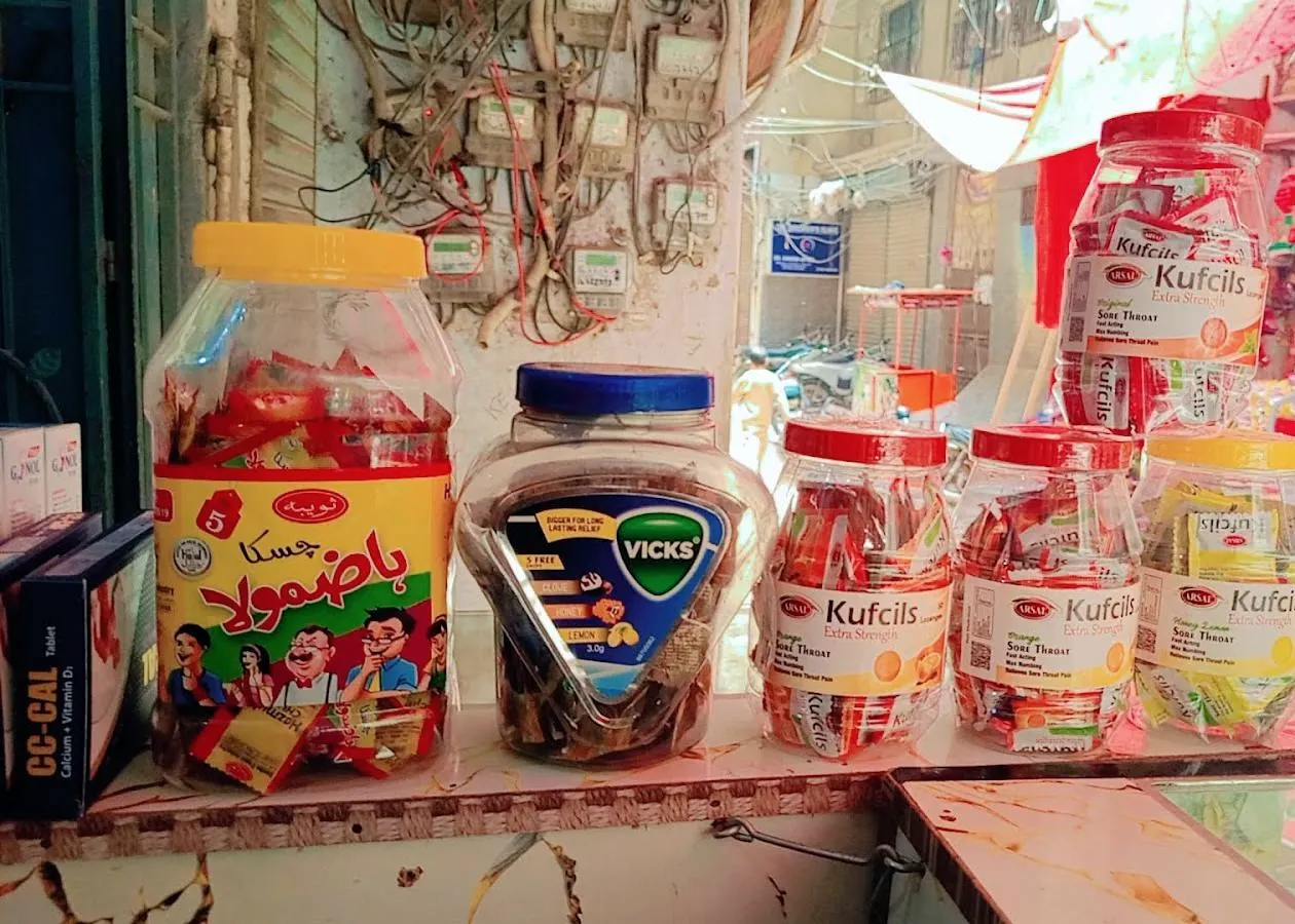 Jars of lozenges and sweets on the shop counter, with the street behind